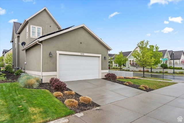 5153 W Bowstring Way S, Jordan, UT 84009 - view of side of home featuring solar panels, concrete driveway, stucco siding, an attached garage, and cooling unit