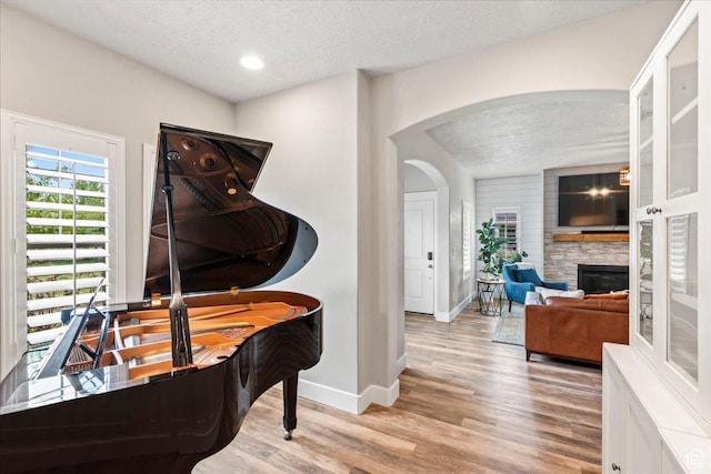5153 W Bowstring Way S, Jordan, UT 84009 - sitting room featuring a textured ceiling, arched walkways, wood finished floors, baseboards, and a fireplace