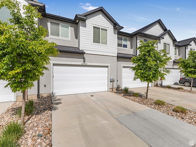 townhome / multi-family property featuring stucco siding, a garage, and concrete driveway