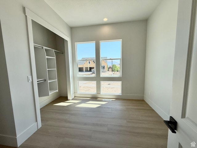 doorway to outside featuring wood finished floors, baseboards, and recessed lighting