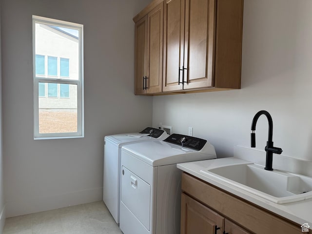 laundry room with washing machine and clothes dryer, cabinet space, and healthy amount of natural light