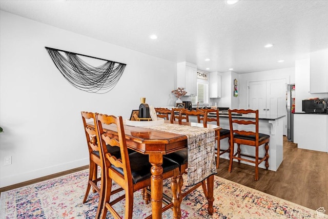 dining space with recessed lighting, light wood finished floors, and baseboards