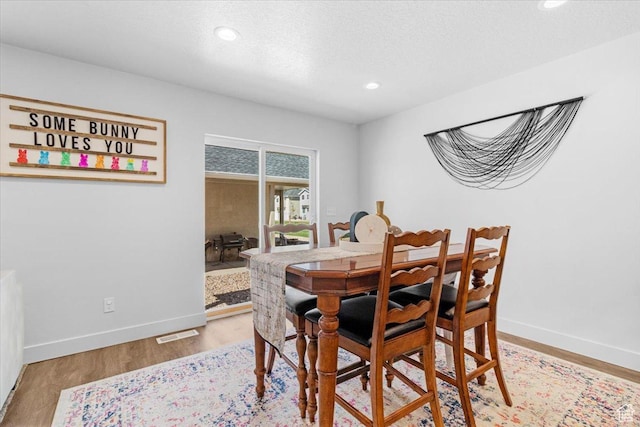 dining area with recessed lighting, baseboards, and light wood finished floors