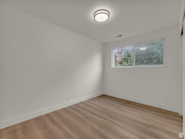 unfurnished room with light wood-style flooring and baseboards