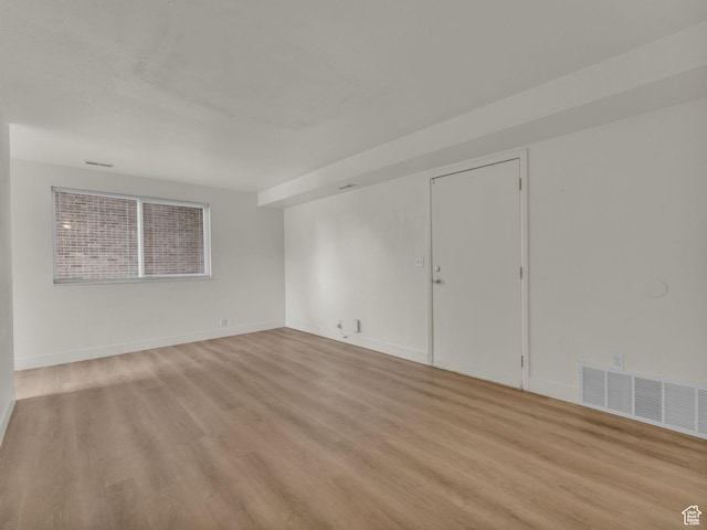 spare room featuring light wood-style floors and baseboards