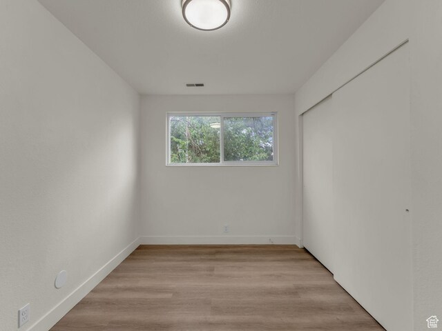 spare room with baseboards and light wood-style floors