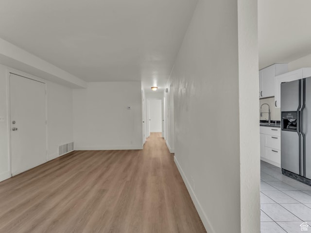 interior space with a sink, light wood-style flooring, and baseboards