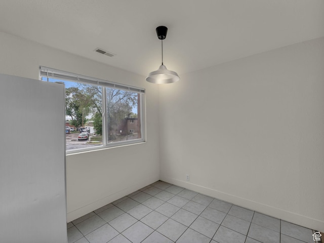 unfurnished dining area featuring light tile patterned floors and baseboards