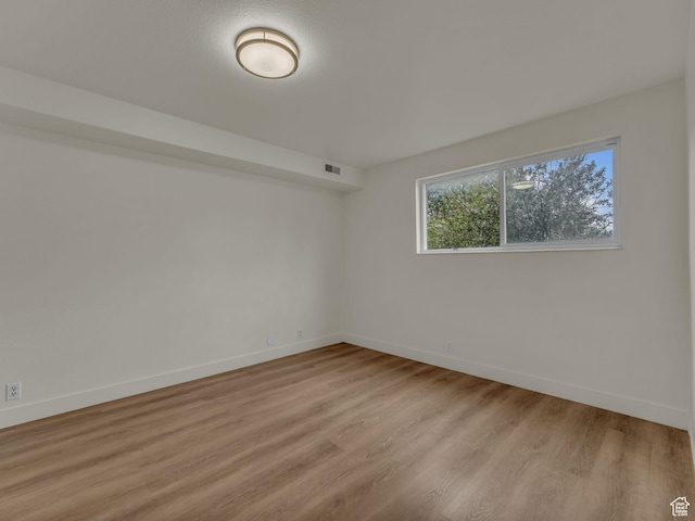 unfurnished room featuring baseboards and light wood-style flooring
