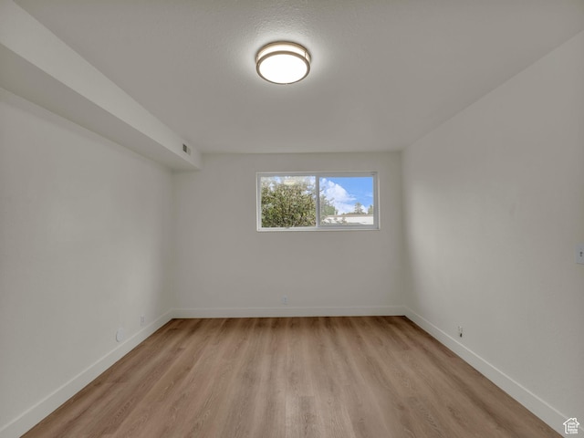 unfurnished room featuring light wood-style floors and baseboards