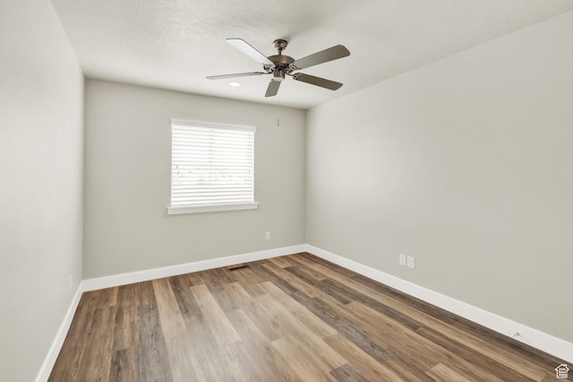 unfurnished room featuring wood finished floors, baseboards, and a ceiling fan