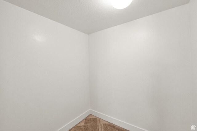 unfurnished room with baseboards and light colored carpet