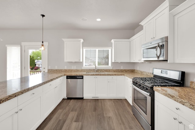 kitchen with stainless steel appliances, a sink, light wood-style floors, white cabinets, and recessed lighting