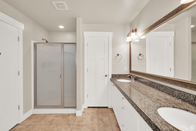 full bath with a stall shower, double vanity, tile patterned floors, and recessed lighting