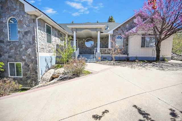 90 S Sherwood Dr, Providence, UT 84332 - property entrance with stone siding, a porch, and a shingled roof