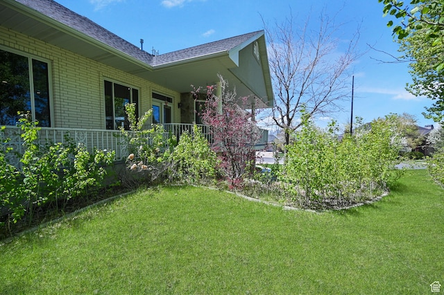 90 S Sherwood Dr, Providence, UT 84332 - view of property exterior featuring brick siding, a yard, and roof with shingles