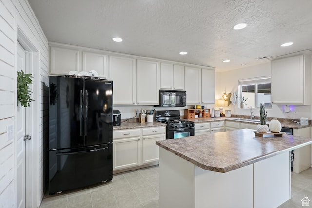 kitchen featuring black appliances, white cabinetry, a sink, recessed lighting, and a textured ceiling