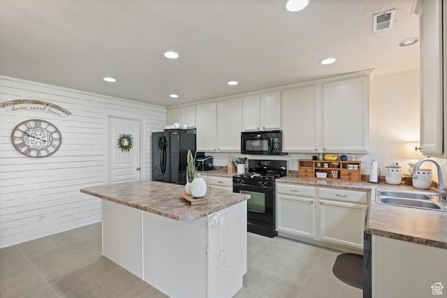 kitchen featuring black appliances, a sink, recessed lighting, a center island, and light countertops