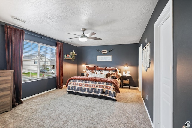 carpeted bedroom with baseboards, a textured ceiling, and a ceiling fan