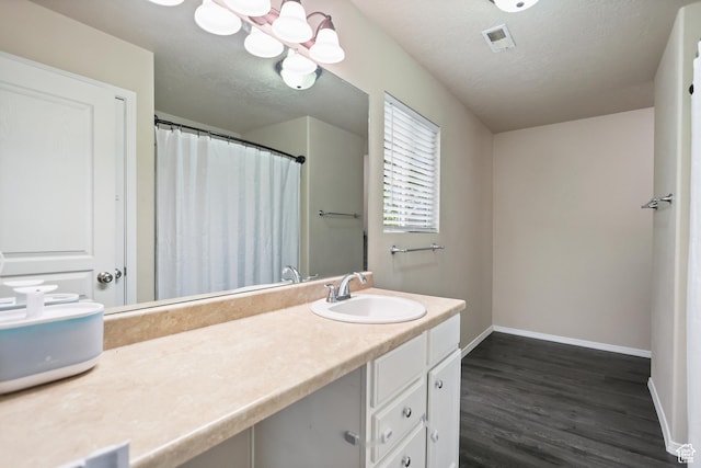 bathroom featuring baseboards, wood finished floors, a textured ceiling, vanity, and a shower with curtain