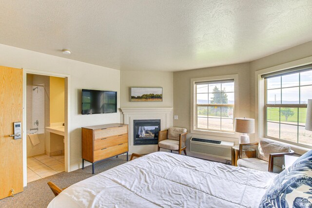 40 N Christa Cir, Garden City, UT 84028 - bedroom featuring an AC wall unit, a textured ceiling, a glass covered fireplace, tile patterned flooring, and carpet floors