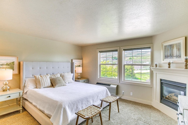 40 N Christa Cir, Garden City, UT 84028 - bedroom featuring a wall mounted AC, light colored carpet, a glass covered fireplace, a textured ceiling, and baseboards