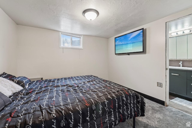 carpeted bedroom featuring baseboards, a textured ceiling, and a sink