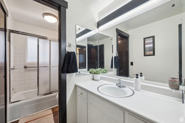 full bathroom featuring vanity, combined bath / shower with glass door, and wood finished floors