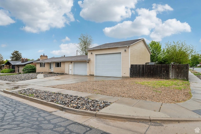 single story home featuring an attached garage, fence, and driveway