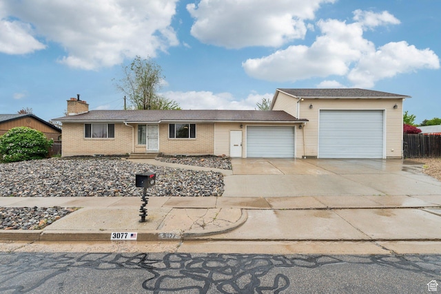 single story home with a garage, driveway, entry steps, brick siding, and a chimney