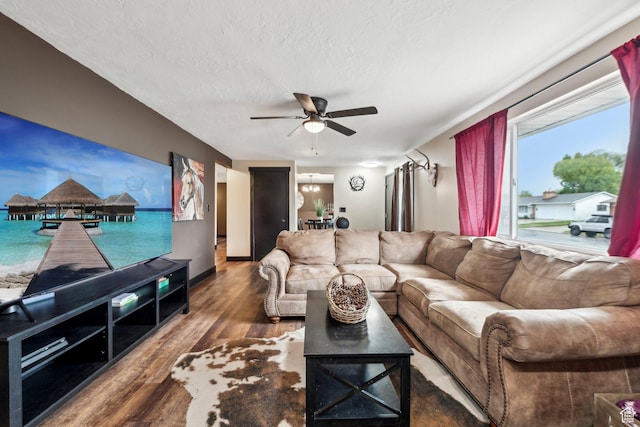 living area featuring a ceiling fan, wood finished floors, and a textured ceiling