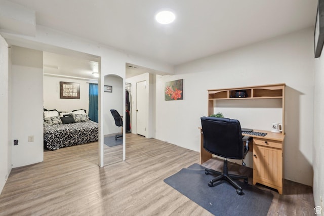 home office featuring light wood-type flooring and built in desk