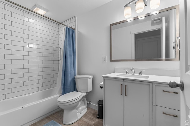 full bath with toilet, wood finished floors, vanity, and shower / bath combo