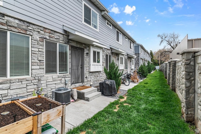 view of green lawn with central AC unit and a residential view
