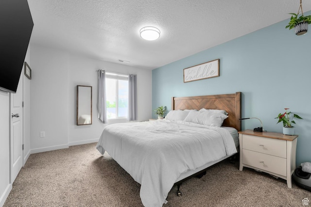 bedroom with a textured ceiling, light carpet, and baseboards