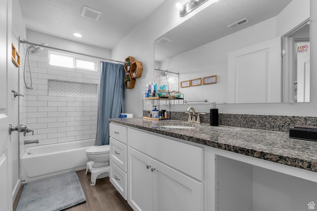 full bathroom featuring wood finished floors, vanity, shower / bath combination with curtain, and toilet