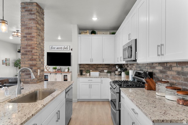 2546 N Wister Ln Unit 334, Lehi, UT 84043 - kitchen featuring appliances with stainless steel finishes, a sink, white cabinets, light wood finished floors, and decorative backsplash