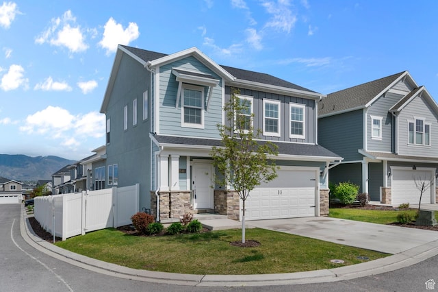 2546 N Wister Ln Unit 334, Lehi, UT 84043 - view of front of home featuring a garage, driveway, a mountain view, board and batten siding, and stone siding