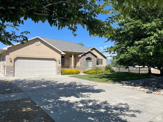 view of front facade with stone siding, stucco siding, an attached garage, and driveway