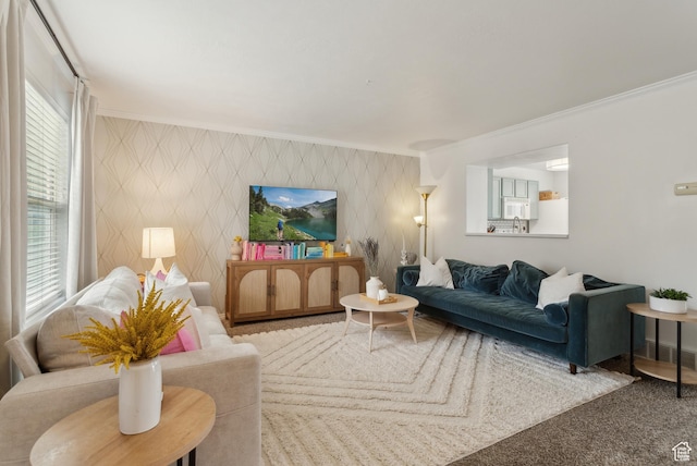 carpeted living room with ornamental molding and an accent wall