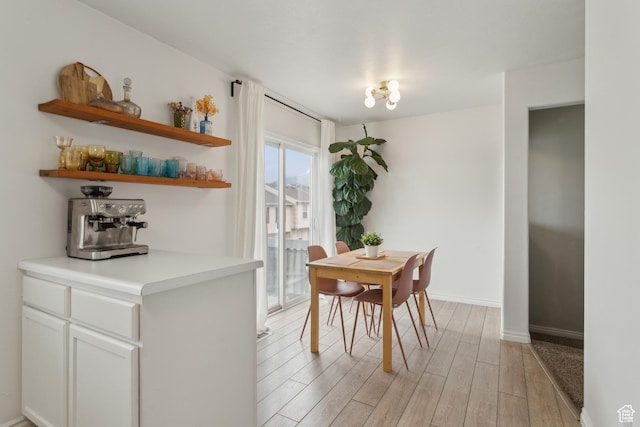 dining area featuring light wood-style floors and baseboards