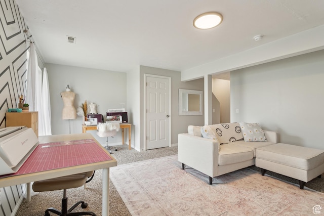 living room featuring a desk, light carpet, and baseboards
