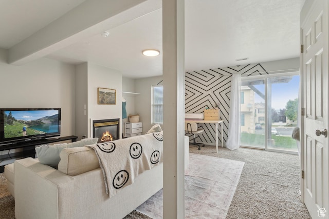 living room with carpet, a glass covered fireplace, healthy amount of natural light, and an office area