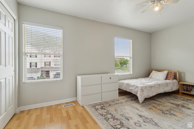 bedroom featuring light wood-style flooring, baseboards, and ceiling fan