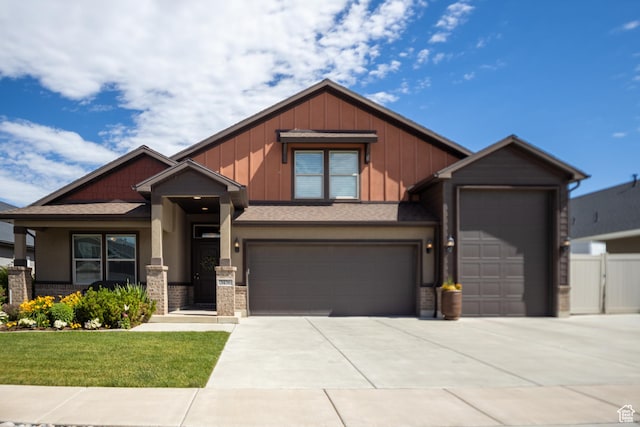 craftsman house with concrete driveway, an attached garage, board and batten siding, and stucco siding