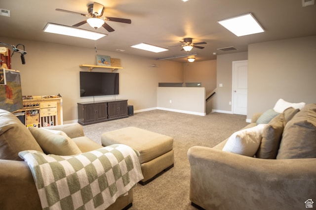 carpeted living area featuring a ceiling fan, baseboards, and a skylight