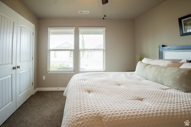 carpeted bedroom featuring a closet, baseboards, and ceiling fan