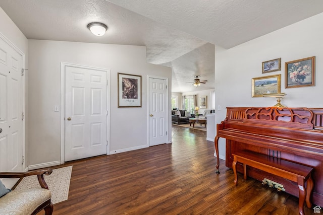 sitting room with wood finished floors, baseboards, a textured ceiling, and a ceiling fan