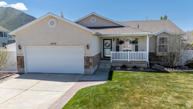 ranch-style home with stone siding, a porch, an attached garage, driveway, and a front yard