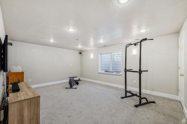 exercise area featuring a textured ceiling, carpet floors, baseboards, and recessed lighting